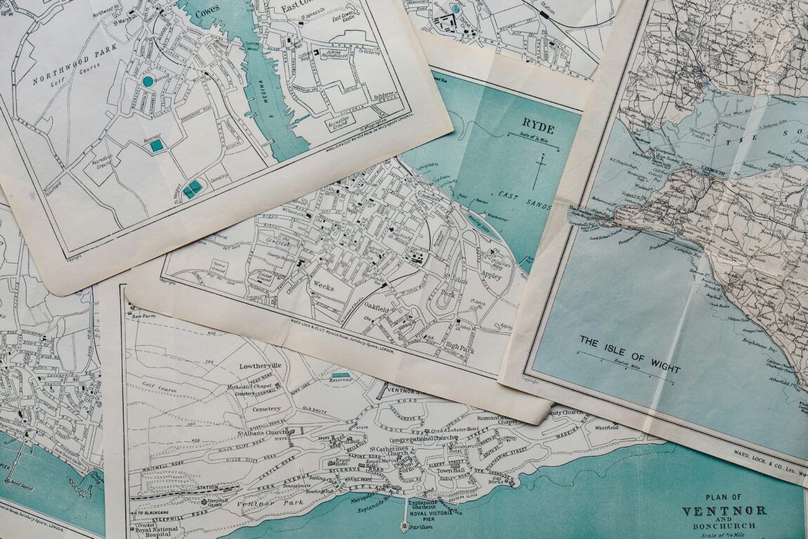 Flatlay of multiple paper maps for Travel Mistakes blog posts.