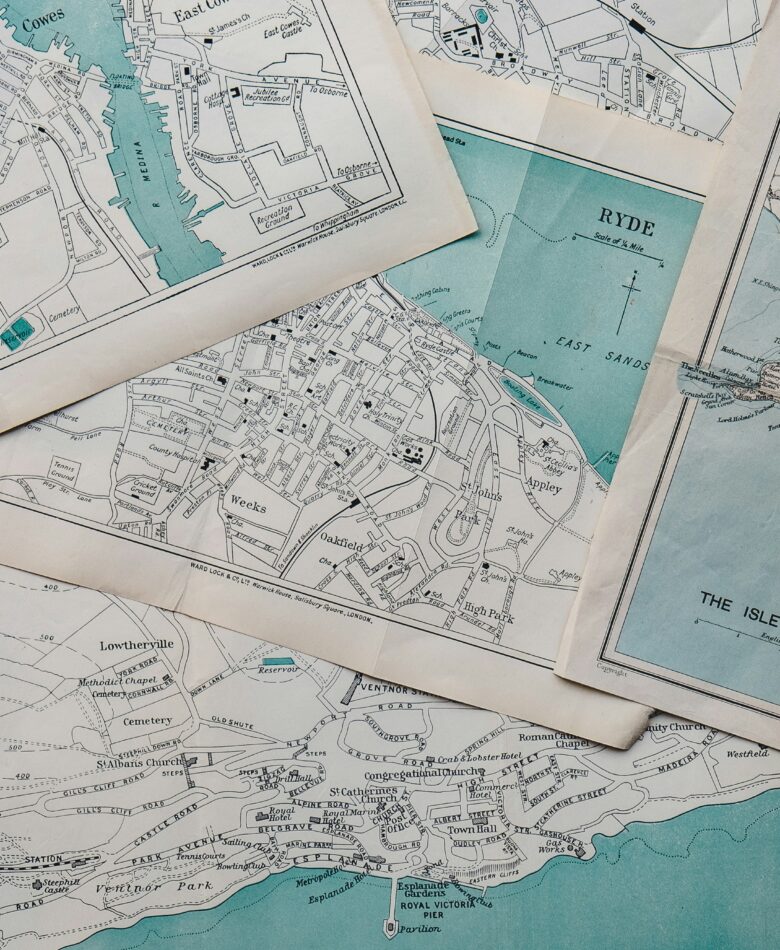 Flatlay of multiple paper maps for Travel Mistakes blog posts.
